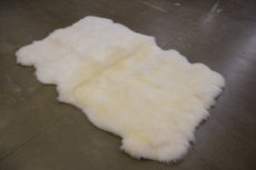 Wit schapenvacht tapijt met zelfde haarlengte.